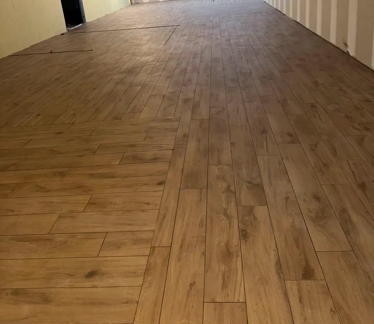 Sol de grand local professionnel en carrelage effet bois, avec changement de sens de pose