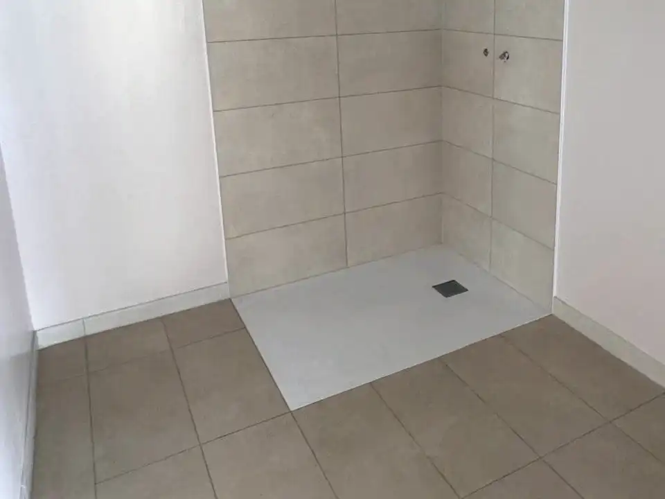 Douche de plain-pied : carrelage mural beige, receveur extra-plat et sol assorti