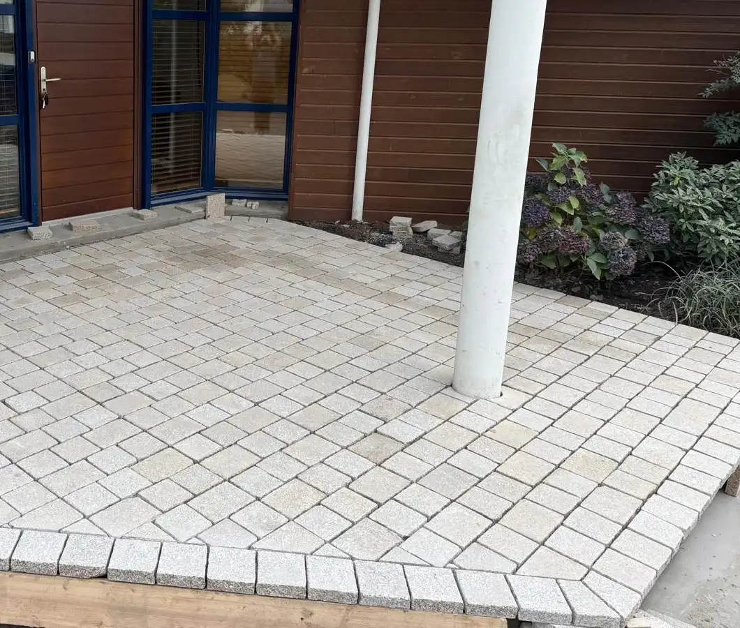 Entrée en pavés de granit clairs posés en diagonale