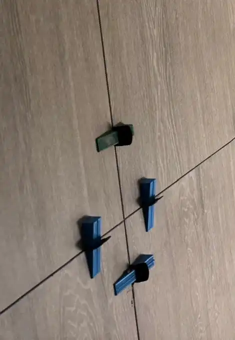 Carreaux grand format effet bois posés au mur avec cales de nivellement